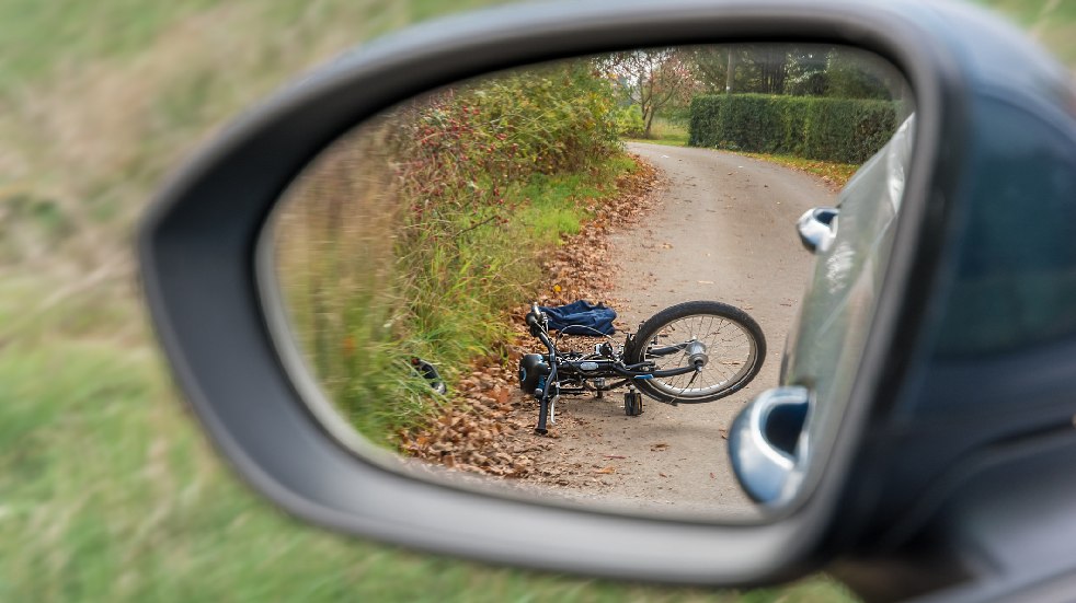 bike accident in rear view mirror of car
